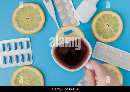 Medikamente, Pillen, Thermometer, traditionelle Medizin für die Behandlung von Erkältungen, Grippe, Wärme auf einem blauen Hintergrund. Aufrechterhaltung der Immunität. Saisonale Krankheiten. Stockfoto