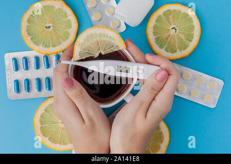 Medikamente, Pillen, Thermometer, traditionelle Medizin für die Behandlung von Erkältungen, Grippe, Wärme auf einem blauen Hintergrund. Aufrechterhaltung der Immunität. Saisonale Krankheiten. Stockfoto