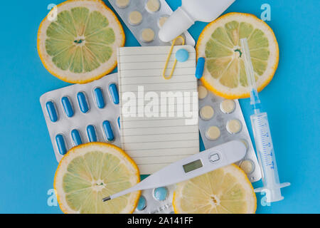 Medikamente, Pillen, Thermometer, traditionelle Medizin für die Behandlung von Erkältungen, Grippe, Wärme auf einem blauen Hintergrund. Aufrechterhaltung der Immunität. Saisonale Krankheiten. Stockfoto
