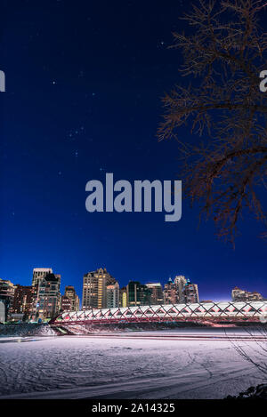 Orion in einer klaren Nacht über die Fußgängerzone Peace Bridge und das Bow River in Calgary, Kanada. Stockfoto