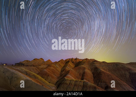 Star Trails rund um den nördlichen Himmelspol oberhalb der Zhangye Danxia Relief in China. Stockfoto