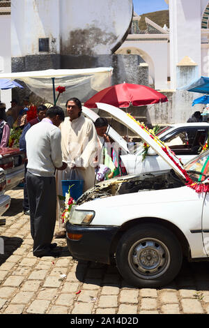 COPACABANA, BOLIVIEN - Oktober 20, 2014: Unbekannter Priester segnet Fahrer/Besitzer eines Autos bei der Einweihung der Automobile in Copacabana, Bolivien Stockfoto