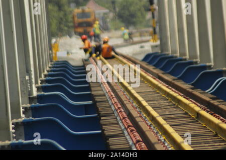 Eine Reihe von Arbeitnehmern wurden gesehen, die Double Track- und Brückenbau Projekt über den Madiun Winongo Fluß, Dorf, Stadt, Madiun Montag, 23. September 2019. Die double Track wurde durch das Ministerium für Verkehr der Republik Indonesien, in diesem Fall der Generaldirektion der Eisenbahnen [Dirjenkerta] durch die Madiun Kedung Dual Line Arbeitseinheit Banteng [JGMK] fährt fort, seine Arbeiten zu beschleunigen. Die 57 km Strecke, die beginnt, von km 164 000 km 221 000, ist der Arbeitsbereich der Ost Java II Engagement Teekocher [PPK] Autorität. Der Plan, wenn PT. Indonesischen Eisenbahn/KAI Re Stockfoto