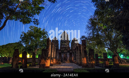 Star Trails rund um den nördlichen Himmelspol vor einem Tempel in Sukhothai, Thailand. Stockfoto