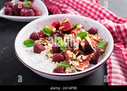 Chia Samen Pudding mit Himbeeren, Feigen und Minze auf dunklem Hintergrund. Das Konzept der guten Ernährung. Stockfoto