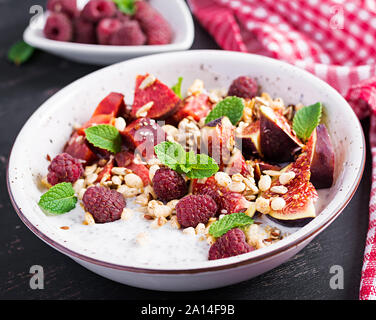 Chia Samen Pudding mit Himbeeren, Feigen und Minze auf dunklem Hintergrund. Das Konzept der guten Ernährung. Stockfoto