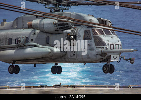 Eine Mannschaft Leiter an Bord der CH-53E Super Stallion Hubschrauber mit speziellen Zweck Marine Air-Ground Task Force - südliche Befehl führt den Piloten eine sichere Landung auf dem Deck der USS Carter Hall (LSD 50) Während deck Qualifikationen in den Atlantischen Ozean Sept. 17, 2019. Deck Qualifikationen werden die Piloten zu bescheinigen Ship-to-shore Operationen durchführen, die Verbesserung der Fähigkeiten der Task Force. Die Task Force ist die Durchführung von Training und Engineering Projekte Hand in Hand mit Partner Nation militärische Mitglieder in Lateinamerika und in der Karibik während ihrer Bereitstellung in der Region, die Zusammenfällt Stockfoto