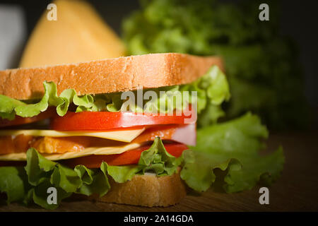 Helle saftige Sandwich mit Kräutern und Tomaten auf einem Schneidebrett Stockfoto