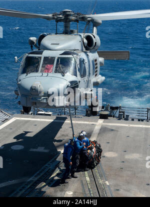 Segler Haken ein cargo-Kabel an eine SH-60B Seahawk Helikopter. Stockfoto