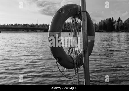 Ein rettungsring an einem See auf einer frühen Herbst morgen im Norden Finnlands hängen. Die Sonne ist langsam in den Hintergrund. Stockfoto