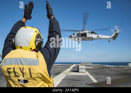 Der Luftfahrt Bootsmann Mate leitet eine MH-60S Sea Hawk Hubschrauber. Stockfoto