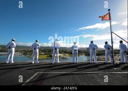 Us-Matrosen und Marines die Schienen an Bord der USS Theodore Roosevelt Mann. Stockfoto