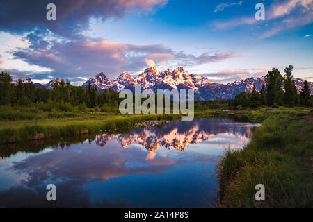 Sonnenaufgang Blick auf Teton Bergkette in ruhigen Snake River im Grand Teton National Park, Wyoming, USA widerspiegelt Stockfoto