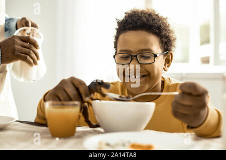 Kind Mit Brille vorgibt, das Spielzeug zu füttern. Stockfoto