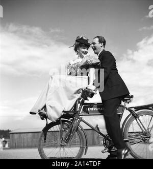 1940 s Paar auf einem Fahrrad. Ein junges Paar ist, ihre Fahrräder an einem sonnigen Tag. Sie sind beide Akteure; Sonja Wigert und Arnold Sjöstrand und sie Spaß haben, während sie ihre neuen Film aufnehmen. Schweden 1944. Foto Kristoffersson K 23-6 Stockfoto