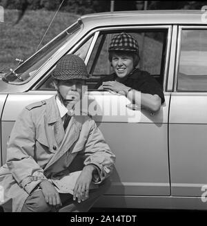 Das Fahren in den 1960er Jahren. Auto Helme wurde in Schweden eingeführt, um die persönliche Sicherheit zu encrease, wenn die Autos fahren. Die Hersteller der Helme hoffte, die Verkäufe von ihnen würde durch die bevorstehende Änderung vom Fahren auf der linken Seite auf der Straße verstärkt werden, auf der rechten Seite. Seltsamerweise weniger Unfälle geschehen dann vor der Änderung. Abgebildet ist ein junges Paar ihre Helme, die unterschiedlich für Männer und Frauen vorgenommen wurden, tragen. Schweden 1966 ref CV 38-2 Stockfoto