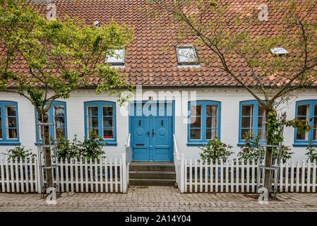 Alten dänischen Haus mit blauen Fenstern und einem weißen Zaun auf der Insel Aero, ÆRØSKØBING, Dänemark, 13. Juli 2019 Stockfoto