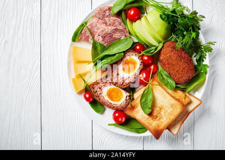 Toast, Cheddar Käse, Apfel, schottische Eier, geschnittenem Kopf, Käse, Tomaten, Spinat, hot Senf, eingelegte Zwiebeln, die traditionellen Pflüger Mittagessen auf einer Plat Stockfoto