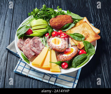 Toast, Cheddar Käse, Apfel, schottische Eier, geschnittenem Kopf, Käse, Tomaten, Spinat, hot Senf, eingelegte Zwiebeln, die traditionellen Pflüger Mittagessen auf einer Plat Stockfoto