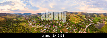 180 Grad Panoramablick auf die Landschaft der Landschaft, Antenne drone Ansicht der städtischen Dorf Pidbuzh in den Karpaten, in der Ukraine. Sonnenuntergang, Ende des Sommers. Stockfoto