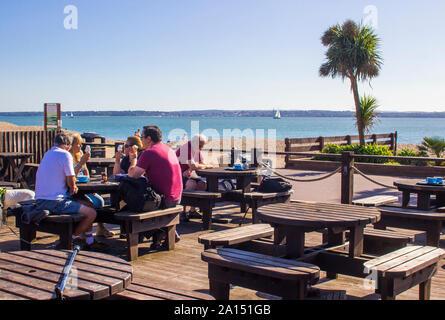 17. September 2019 Entspannen bei Kaffee und Eis im Spätsommer Sonne auf der Hampshire Küste Pebble Beach in der Nähe von Fareham Stockfoto