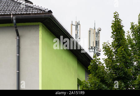 5 G Antennen an der Spitze des Hauses. Antennen und Sendeanlagen auf dem Dach. High speed mobile Internet Konzept. Stockfoto