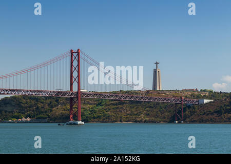 Tagus Fluss, die Brücke "25 de Abril" (25. April Brücke) und das Heiligtum von Christus dem König (Santuario de Cristo Rei) Monument in Lissabon, Portugal. Stockfoto