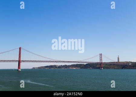 Tagus Fluss, die Brücke "25 de Abril" (25. April Brücke) und das Heiligtum von Christus dem König (Santuario de Cristo Rei) Monument in Lissabon, Portugal. Stockfoto
