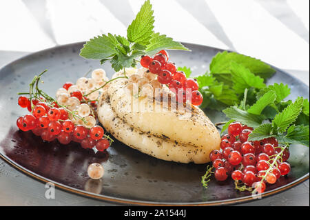 Gegrillter Halloumi-Käse mit roten Johannisbeeren und Minzblättern. Unkonventionelles Servieren von Halloumi-Käse. Landwirtschaftlicher Naturprodukt Stockfoto