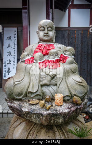 Jizo Statue mit rot Lätzchen in Arashiyama, Kyoto, Japan Stockfoto