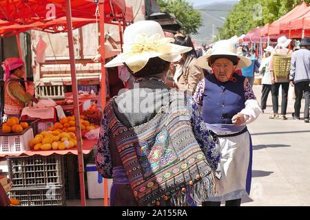 Lokale ethnische Gruppen von Menschen verkaufen und Produkte am Freitag Flohmarkt in Shaxi Dorf der alten Kaffee und -handel Route in Yunnan, China kaufen. Stockfoto