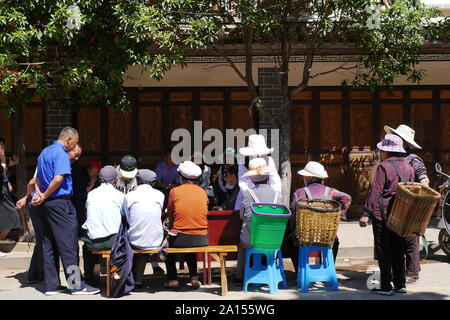 Lokale ethnische Gruppen von Menschen verkaufen und Produkte am Freitag Flohmarkt in Shaxi Dorf der alten Kaffee und -handel Route in Yunnan, China kaufen. Stockfoto