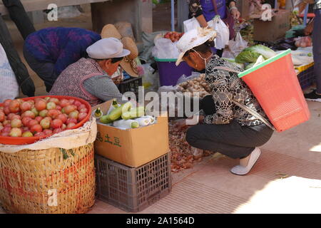 Lokale ethnische Gruppen von Menschen verkaufen und Produkte am Freitag Flohmarkt in Shaxi Dorf der alten Kaffee und -handel Route in Yunnan, China kaufen. Stockfoto
