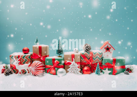 Weihnachtsgeschenke und Ornamente in einer Reihe in der Form eines schneebedeckten Stadtbild Stockfoto