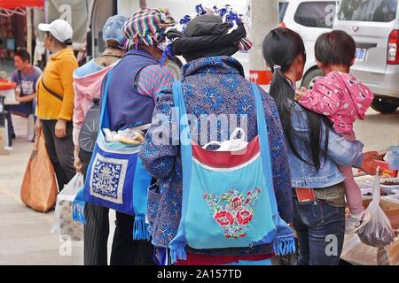 Lokale ethnische Gruppen von Menschen verkaufen und Produkte am Freitag Flohmarkt in Shaxi Dorf der alten Kaffee und -handel Route in Yunnan, China kaufen. Stockfoto