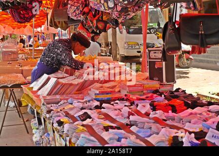Lokalen chinesischen ethnischen Menschen Kauf einige Waren am Freitag Flohmarkt in Shaxi Dorf der alten Kaffee und -handel Route in Yunnan, China. Stockfoto