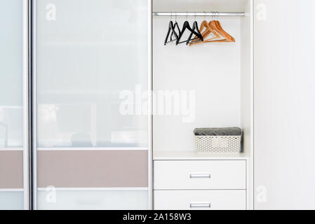 Kleiderschrank mit leeren Regalen und Kleiderbügel. Weißen minimalistischen skandinavischen Interieur. Stockfoto