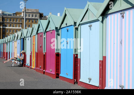 Brighton, East Sussex, England, Großbritannien - 13 September, 2019: eine Linie bunten Badekabinen, der nächste Strand Hütten gross mit einem abnehmenden pe sind Stockfoto