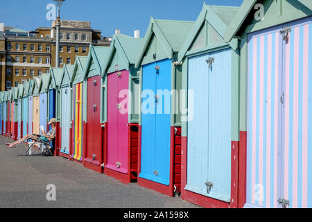 Brighton, East Susses, England, Großbritannien - 13 September, 2019: eine Linie bunten Badekabinen, der nächste Strand Hütten gross mit einem abnehmenden Perspektive sind ein Stockfoto