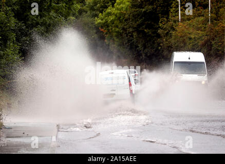 Fahrzeuge gehen durch einen teilweise überschwemmte Straße in der Nähe von Colnbrook, West London. Das Met Office hat eine gelbe Wetter Warnung für viel von England und Wales heute herausgegeben, mit Überschwemmungen in einigen Bereichen zu rechnen. Stockfoto