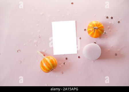 Mockup Postkarte mit kleinen Kürbisse, glitter Dekor auf rosa Hintergrund. Minimal Style Zusammensetzung, Flach, Blick. Stockfoto