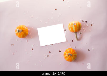 Mockup Postkarte mit kleinen Kürbisse, glitter Dekor auf rosa Hintergrund. Minimal Style Zusammensetzung, Flach, Blick. Stockfoto