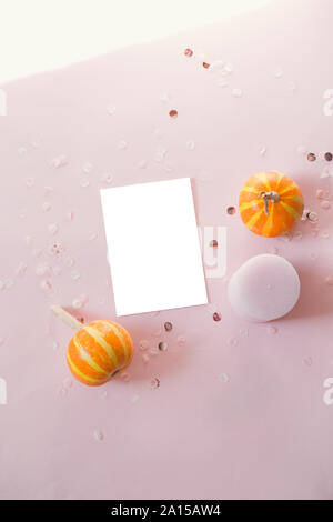 Mockup Postkarte mit kleinen Kürbisse, glitter Dekor auf rosa Hintergrund. Minimal Style Zusammensetzung, Flach, Blick. Stockfoto