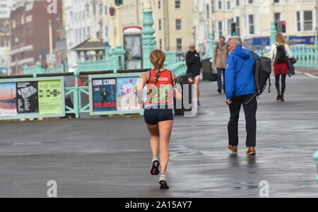 Brighton, UK. 24 Sep, 2019. Ein Läufer braves die Bedingungen auf dem Brighton Seafront wie Wind und Regen zerschlägt die meisten heutigen Großbritannien. Foto: Simon Dack/Alamy leben Nachrichten Stockfoto