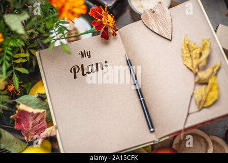 Herbst Satz gelbe Blätter und Blüten. Notebook mit offenen Seiten auf dem Tisch. Platz für Text. Ansicht von oben. Mein Plan Konzept Stockfoto