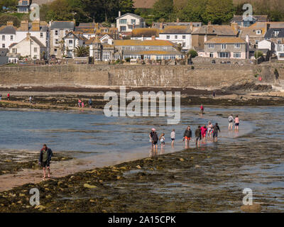 Menschen zu Fuß auf eine teilweise eingetaucht Causeway in Marazion, Cornwall Stockfoto