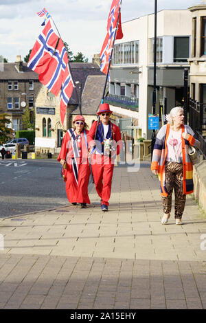 Ein Paar aus Norwegen mit Fahnen auf langen Stöcken, während sie Harrogate für die Straßen-Weltmeisterschaft 2019 besuchen, Harrogate, North Yorkshire, Großbritannien. Stockfoto