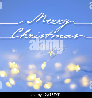 Herzlichen Glückwunsch "Frohe Weihnachten!" auf einem blauen Hintergrund mit Weihnachtsbeleuchtung. Weihnachten festliche Hintergrund Stockfoto