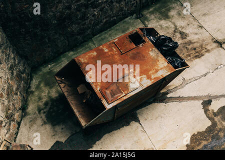 Alten rostigen Müll container voller Müll in Plastiktüten, hohe Betrachtungswinkel Stockfoto