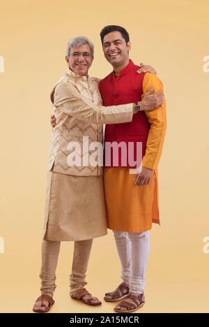 Vater und Sohn umarmen in traditioneller Kleidung Stockfoto